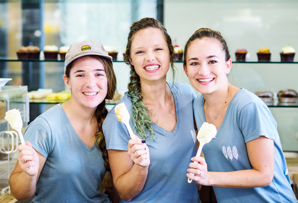Justine and her team from Blue Jay's Bakery holding frosting covered spatulas