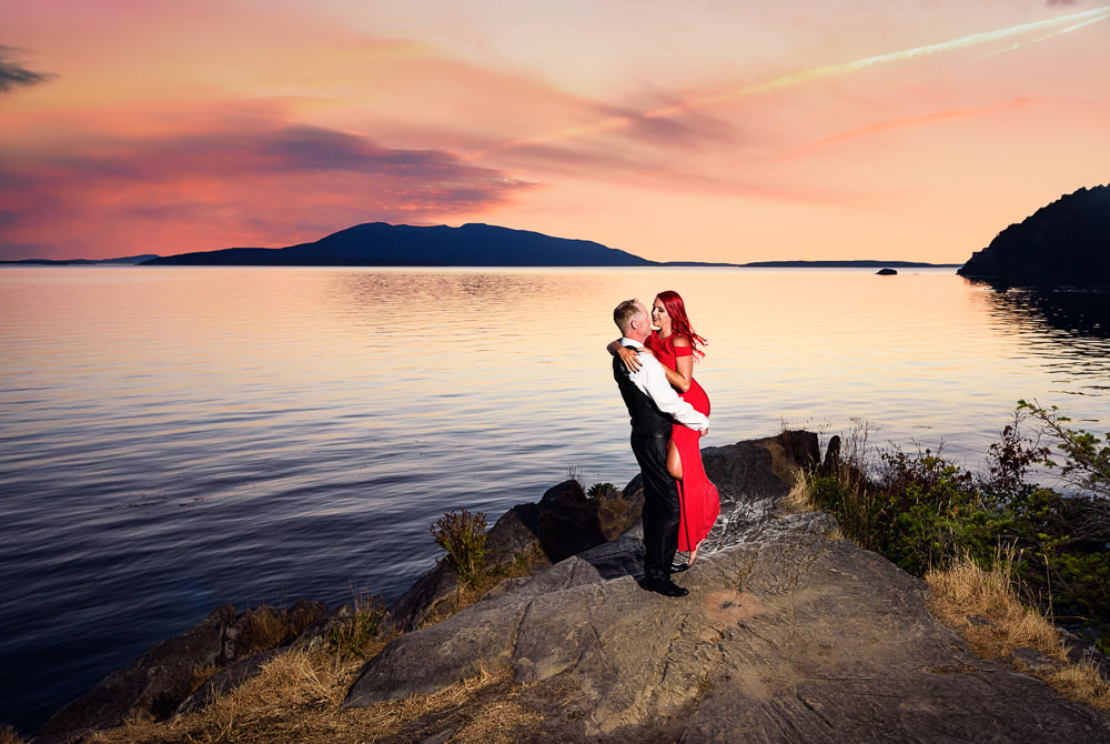 Man picking up woman on the rocks by the water at sunset, red dress, Larrabee State Park Engagement, Lazzat Photography, Engagement photos