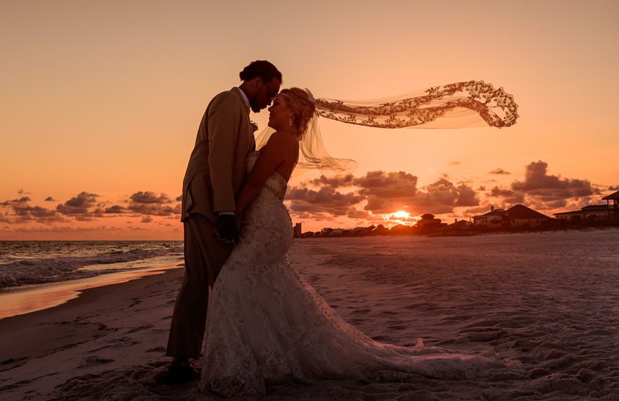 Pensacola Beach Destination Wedding, Delaine and Desireé head to head in the sunset with the veil flying, Lazzat Photography
