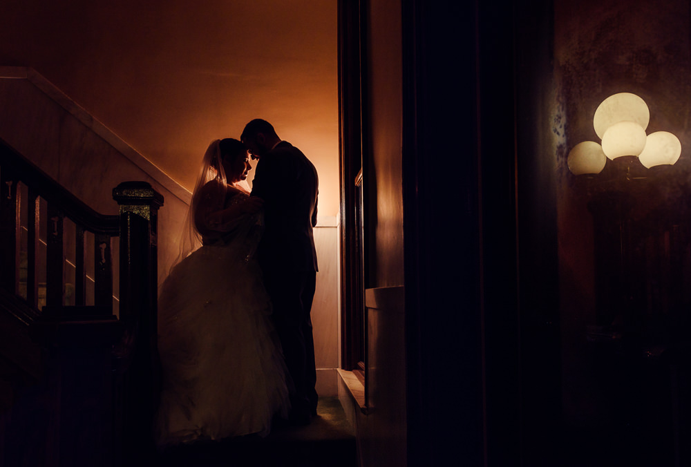 Bride and Groom dark romantic moment in stairwell, Downtown Pensacola Grand Hotel Wedding, Lazzat Photography, Florida wedding photographer