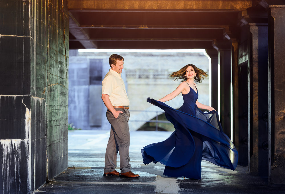 Woman spinning in her blue dress while man watches, Fun Engagement Session at Eden Garden and Fort Pickens, Lazzat Photography, engagement photos