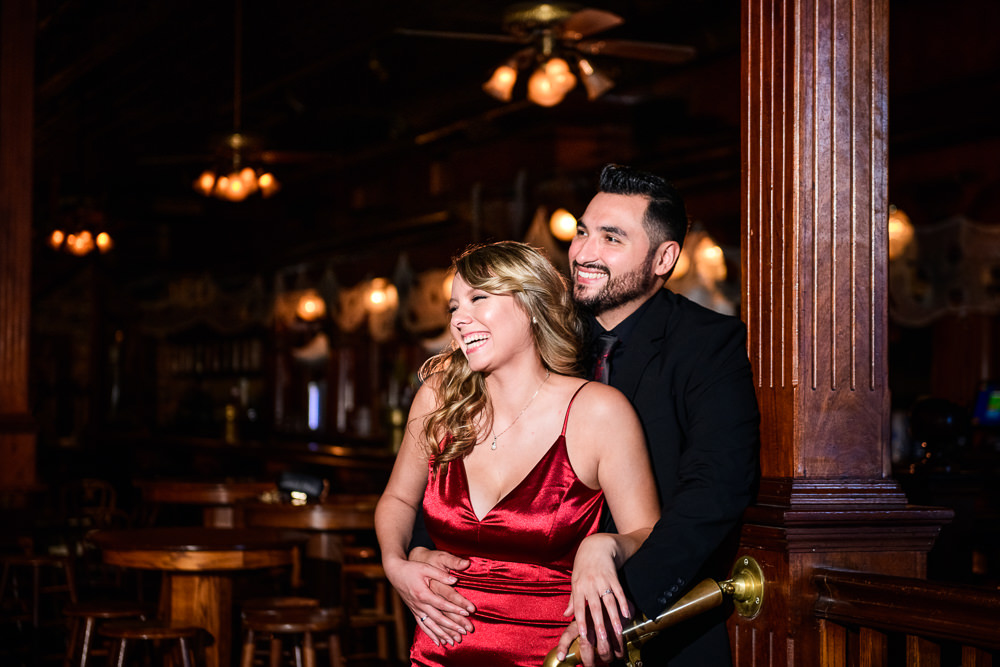 Couple laughing in Seville Quarter, New Orleans Inspired Engagement Session, Long red gown, Pensacola engagement photographer, Lazzat Photography