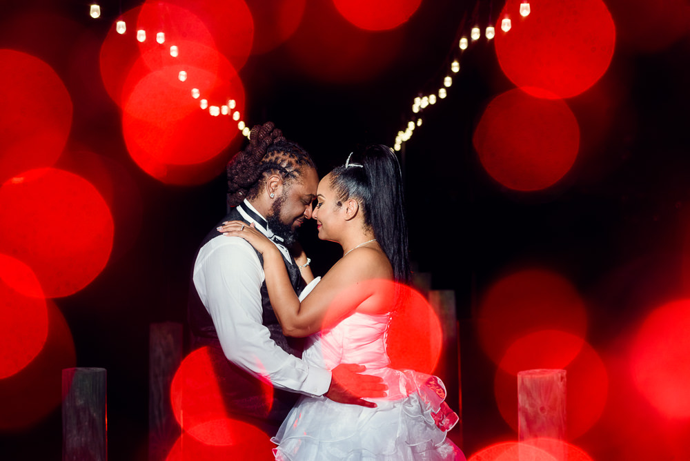 Bride and Groom forehead to forehead at night with red and white twinkle lights, Royal Red Destination Wedding, Florida wedding photographer, Lazzat Photography