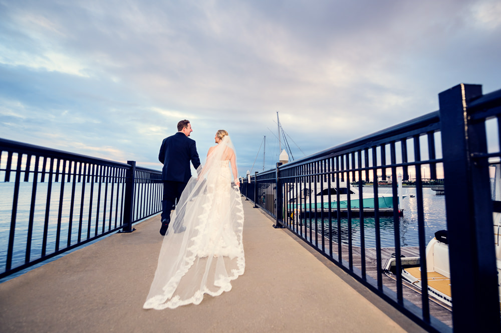 Bride and Groom walking down Palafox Pier, lace wedding dress, long lace veil, Palafox Wharf Pensacola Wedding, Orlando Florida Wedding photographer, Lazzat Photography
