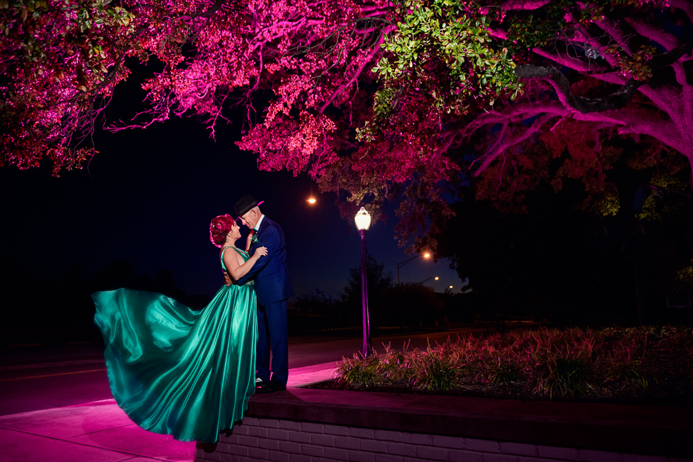 Couple standing on ledge, pink and green lighting, green formal gown, pink hair, EPIC couple shoot, Lazzat Photography