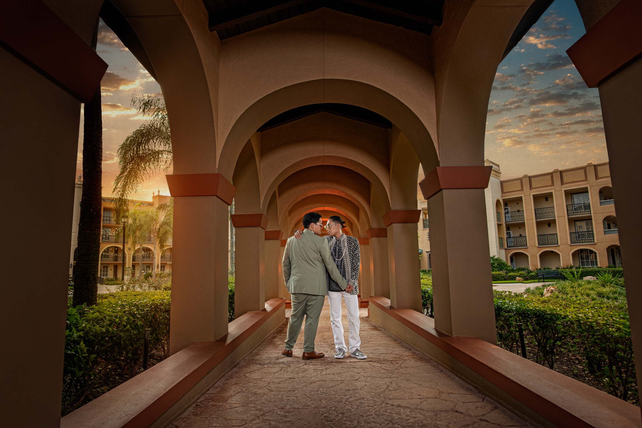 Magical Epcot Wedding | newly weds holding hands under walkway with sunset